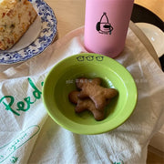 Set of happy ceramic bowls and cups with cheerful designs and vibrant colors