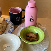 Set of happy ceramic bowls and cups with cheerful designs and vibrant colors