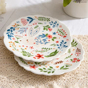 Colorful floral ceramic plates stacked on a table, showcasing intricate and vibrant flower and leaf patterns