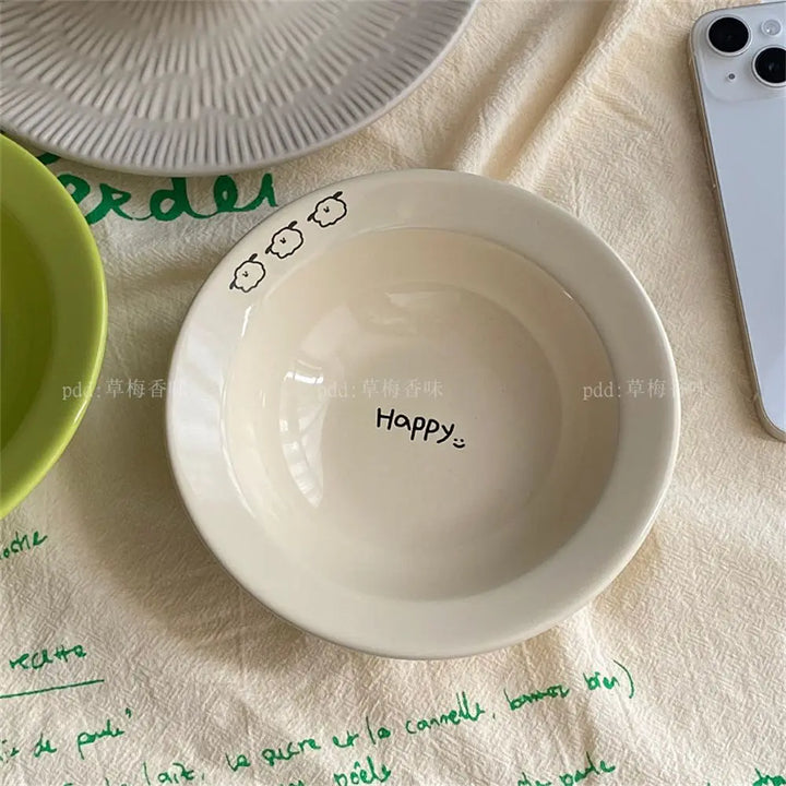 Set of happy ceramic bowls and cups with cheerful designs and vibrant colors