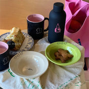 Set of happy ceramic bowls and cups with cheerful designs and vibrant colors