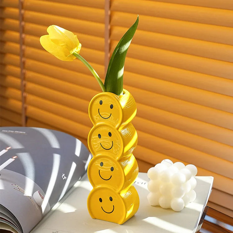 Bright yellow ceramic vase with a hand-painted smiley face