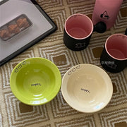 Set of happy ceramic bowls and cups with cheerful designs and vibrant colors