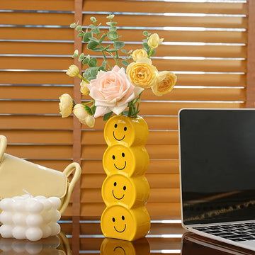 Bright yellow ceramic vase with a hand-painted smiley face