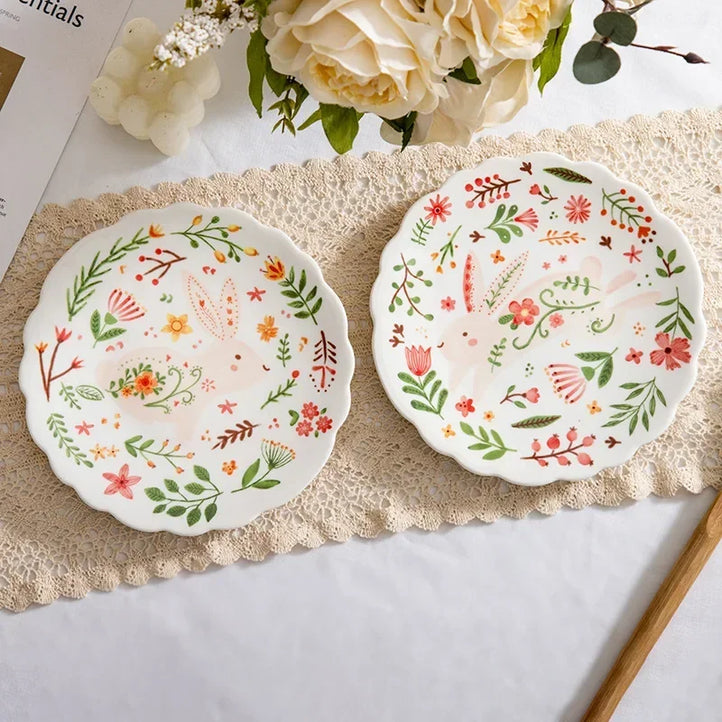 Colorful floral ceramic plates stacked on a table, showcasing intricate and vibrant flower and leaf patterns