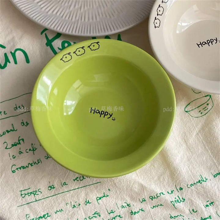 Set of happy ceramic bowls and cups with cheerful designs and vibrant colors