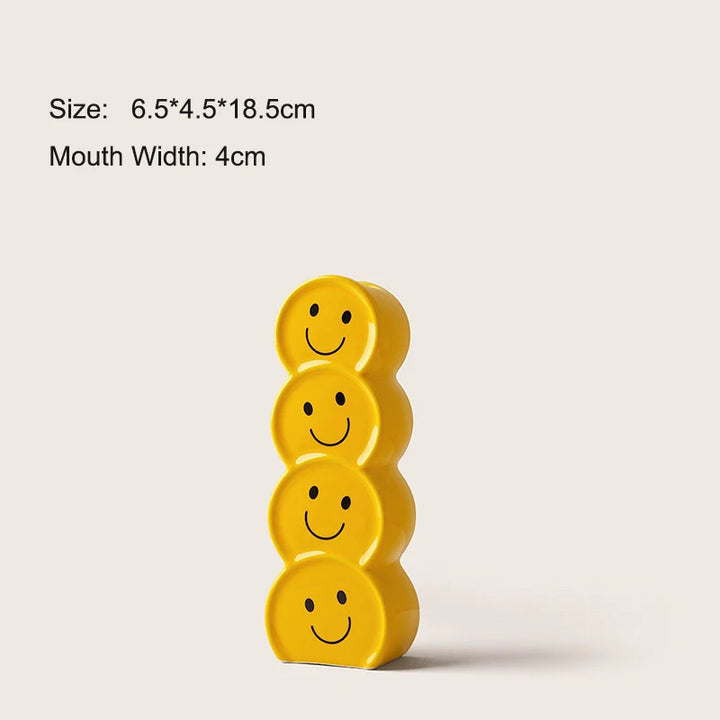 Bright yellow ceramic vase with a hand-painted smiley face