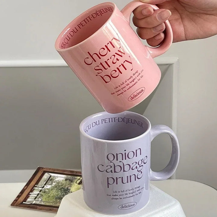 Breakfast-inspired pastel ceramic mugs with playful text designs, featuring unique flavor themes like Salted Basil Butter and Cherry Strawberry, perfect for aesthetic coffee or tea moments
