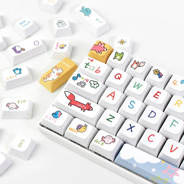 Close-up view of a white keyboard with colorful, hand-drawn Kawaii keycaps, featuring playful icons and symbols on the keys