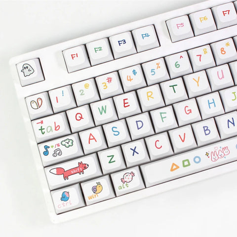 Close-up view of a white keyboard with colorful, hand-drawn Kawaii keycaps, featuring playful icons and symbols on the keys