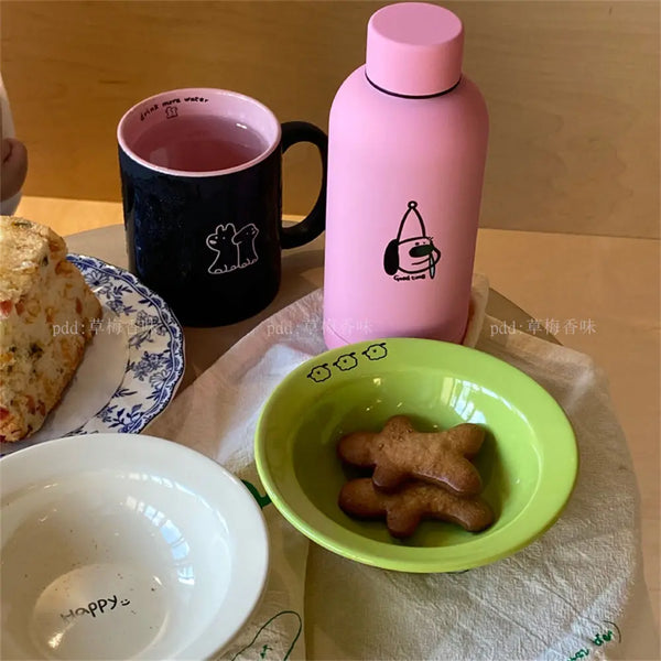 Set of happy ceramic bowls and cups with cheerful designs and vibrant colors