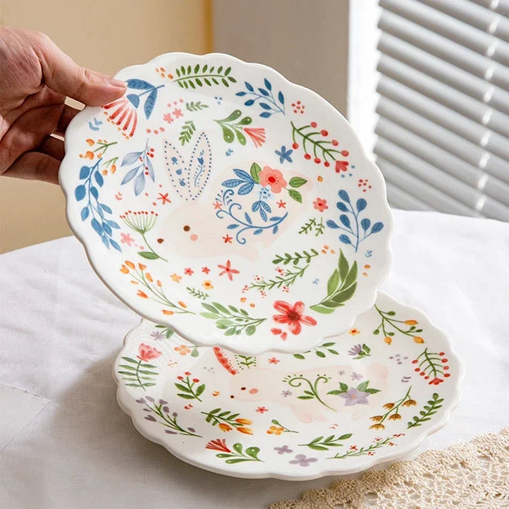 Colorful floral ceramic plates stacked on a table, showcasing intricate and vibrant flower and leaf patterns