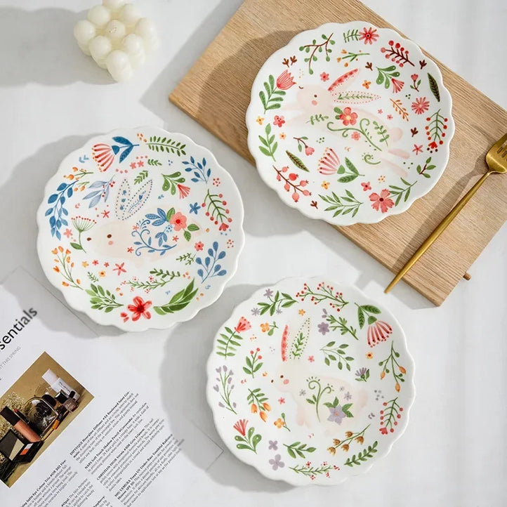 Colorful floral ceramic plates stacked on a table, showcasing intricate and vibrant flower and leaf patterns