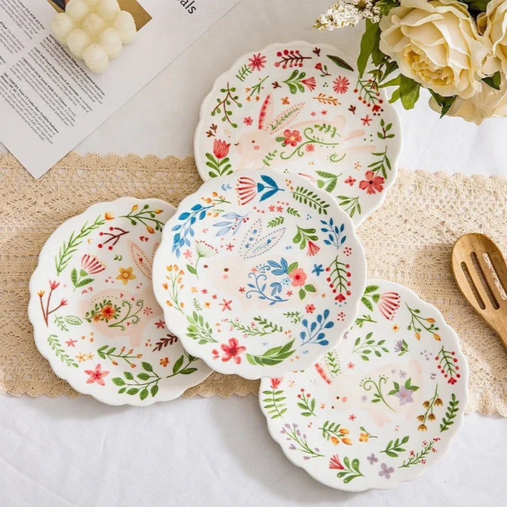 Colorful floral ceramic plates stacked on a table, showcasing intricate and vibrant flower and leaf patterns