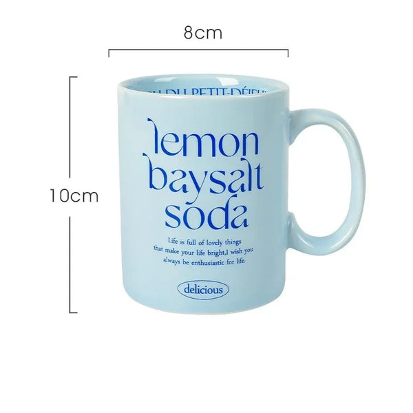 Breakfast-inspired pastel ceramic mugs with playful text designs, featuring unique flavor themes like Salted Basil Butter and Cherry Strawberry, perfect for aesthetic coffee or tea moments