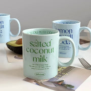 Breakfast-inspired pastel ceramic mugs with playful text designs, featuring unique flavor themes like Salted Basil Butter and Cherry Strawberry, perfect for aesthetic coffee or tea moments