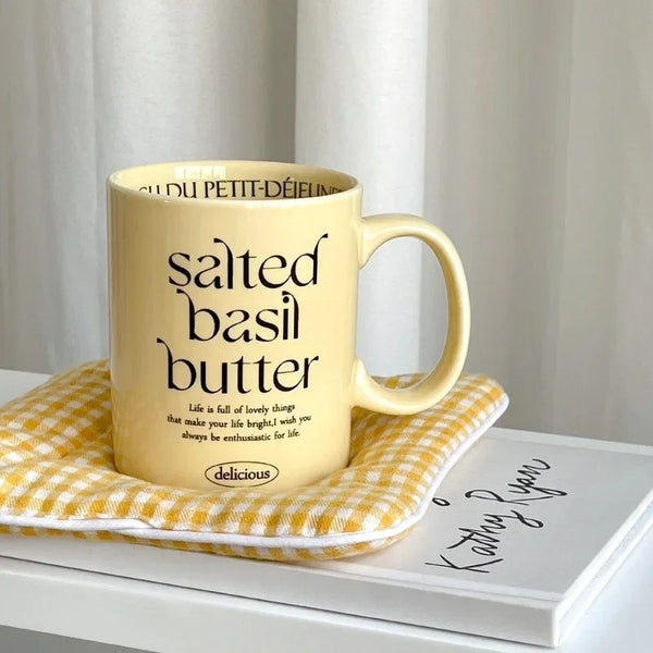 Breakfast-inspired pastel ceramic mugs with playful text designs, featuring unique flavor themes like Salted Basil Butter and Cherry Strawberry, perfect for aesthetic coffee or tea moments